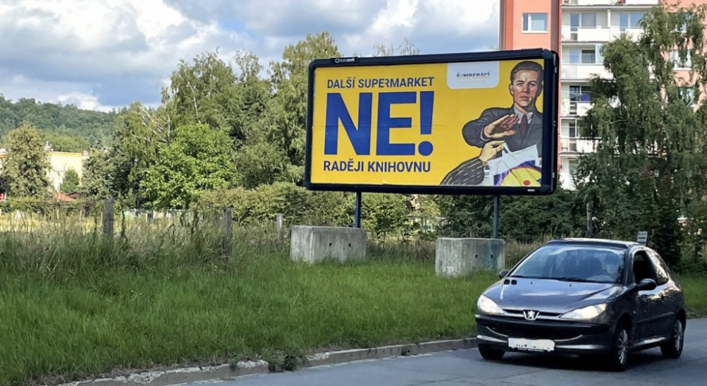 Odpor proti supermarketu symbolizuje billboard přímo na 